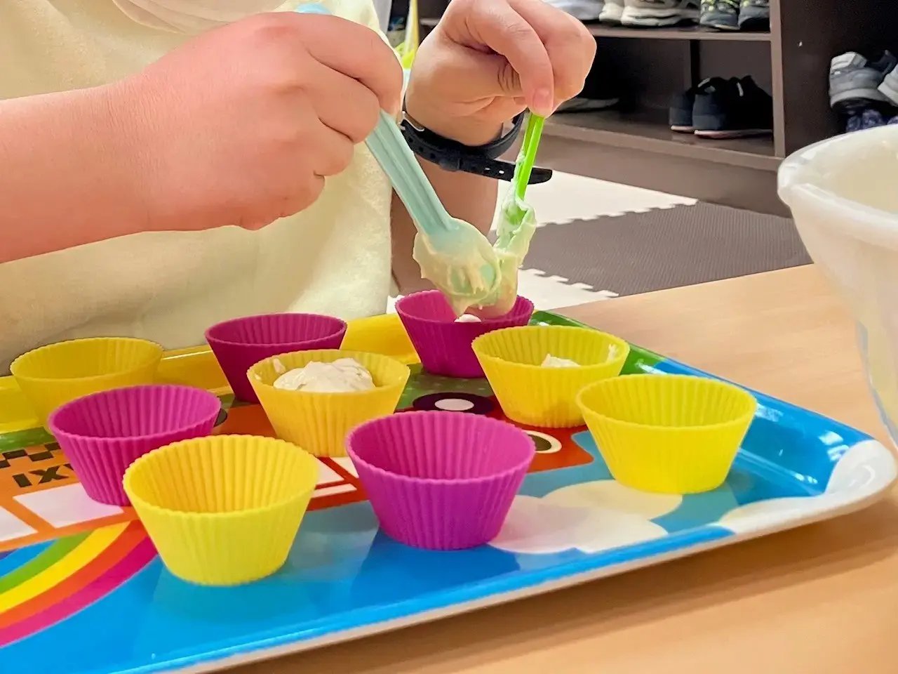 カップに生地を入れる子ども