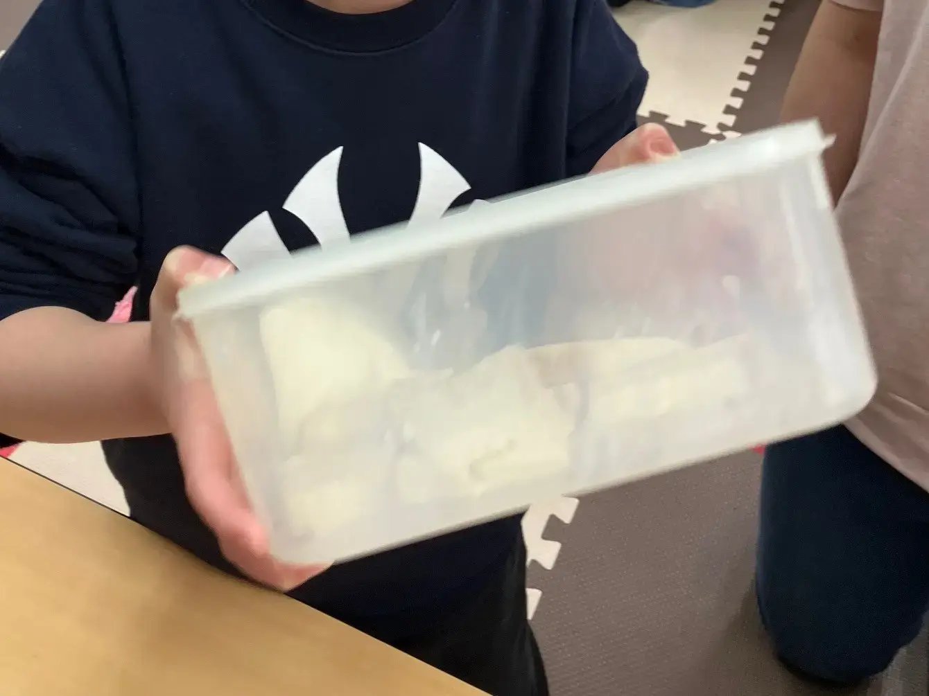 パンにフレンチトーストの液を染み込ませる子ども