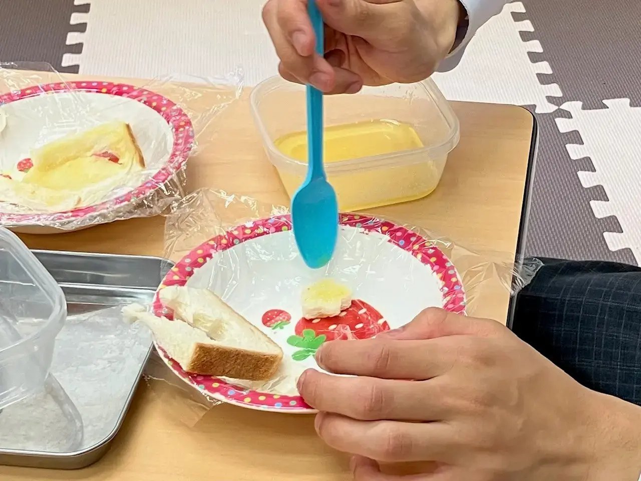 型抜きしたパンにバターを塗る様子