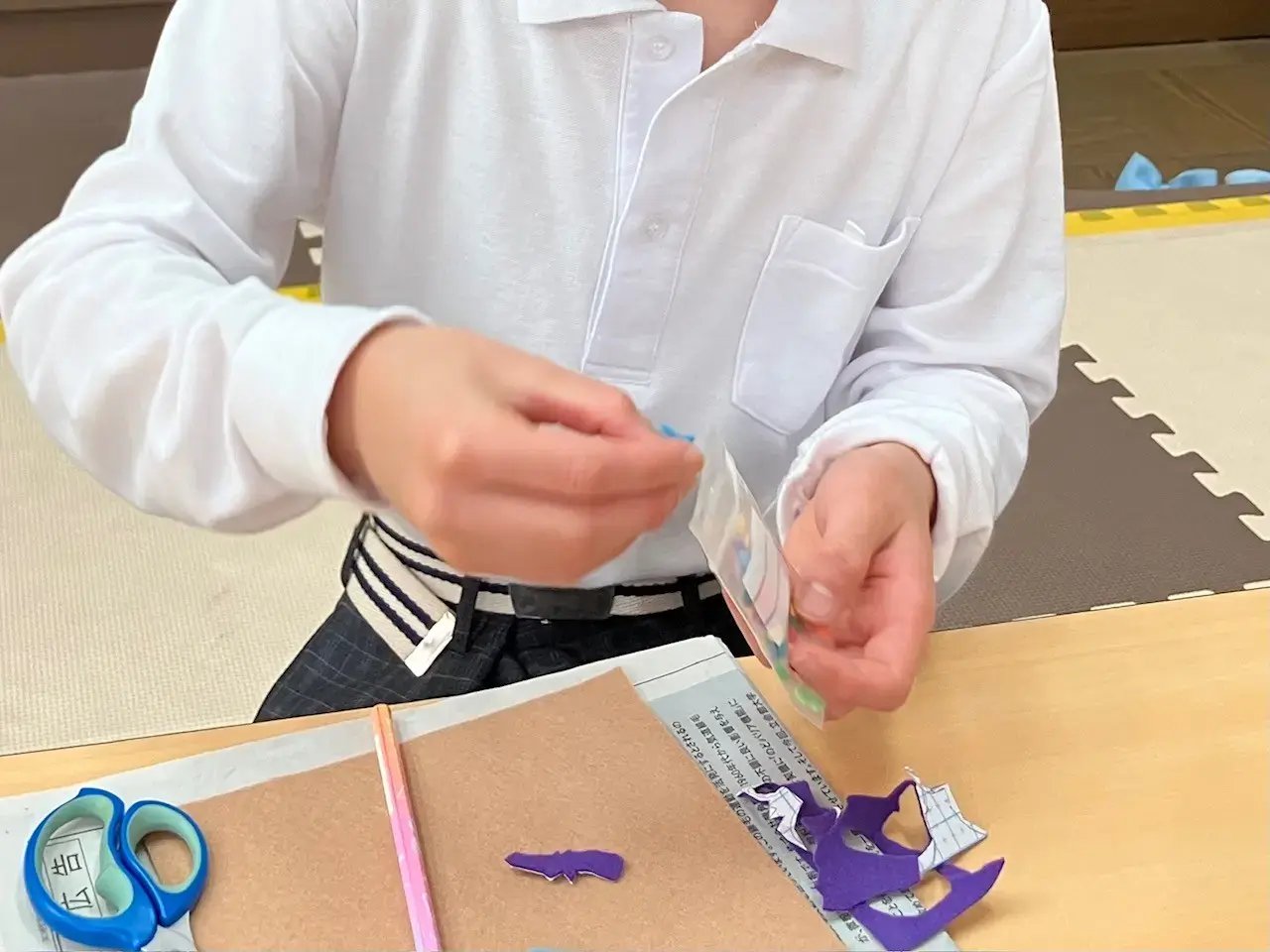 シールフェルトを組み合わせてコウモリを作る子ども