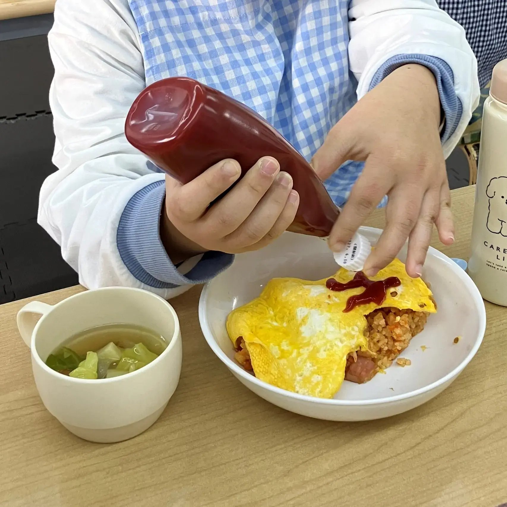 オムライスにケチャップで絵を描いている様子