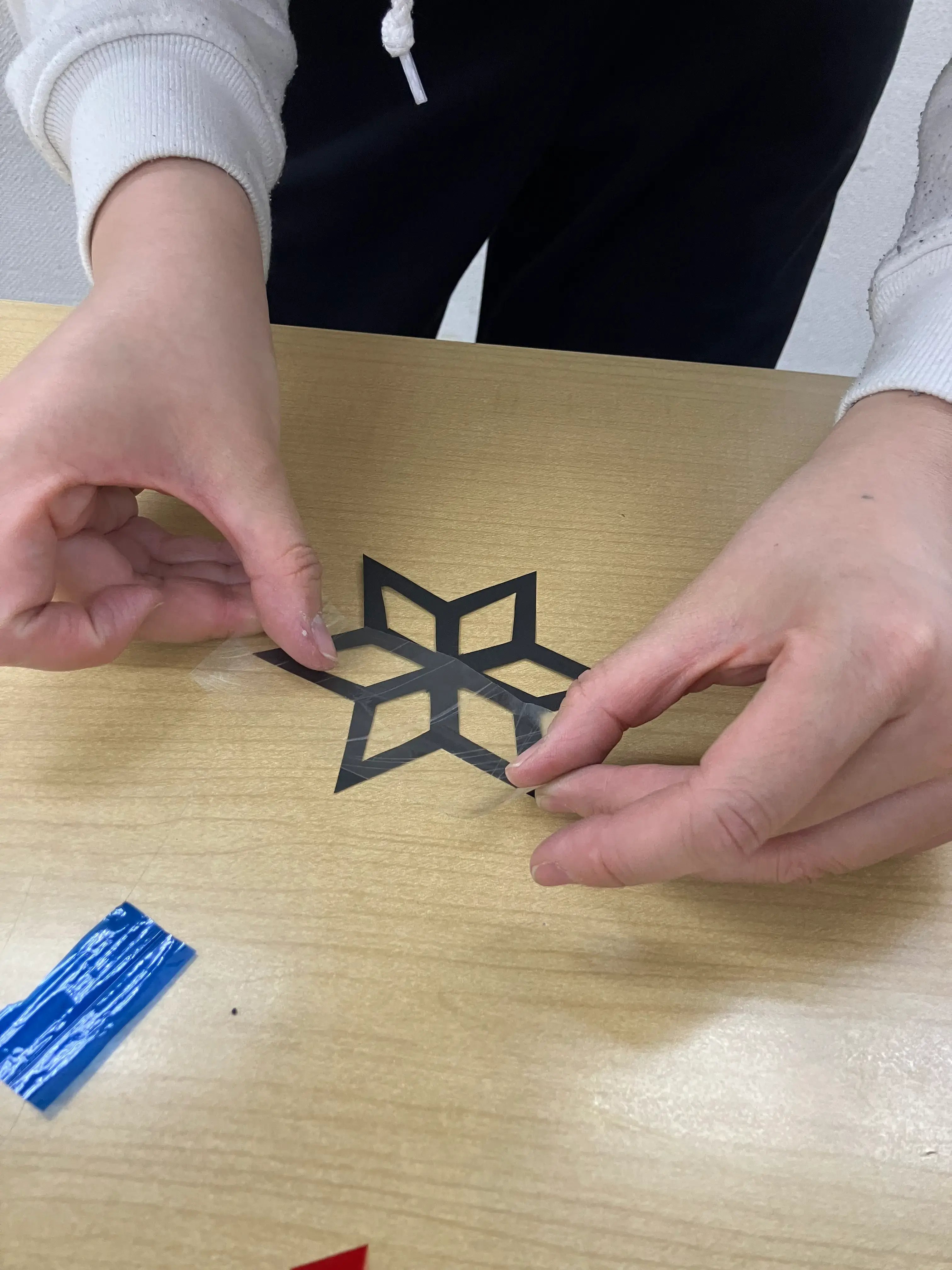 切り絵にセロハンテープを貼っている様子