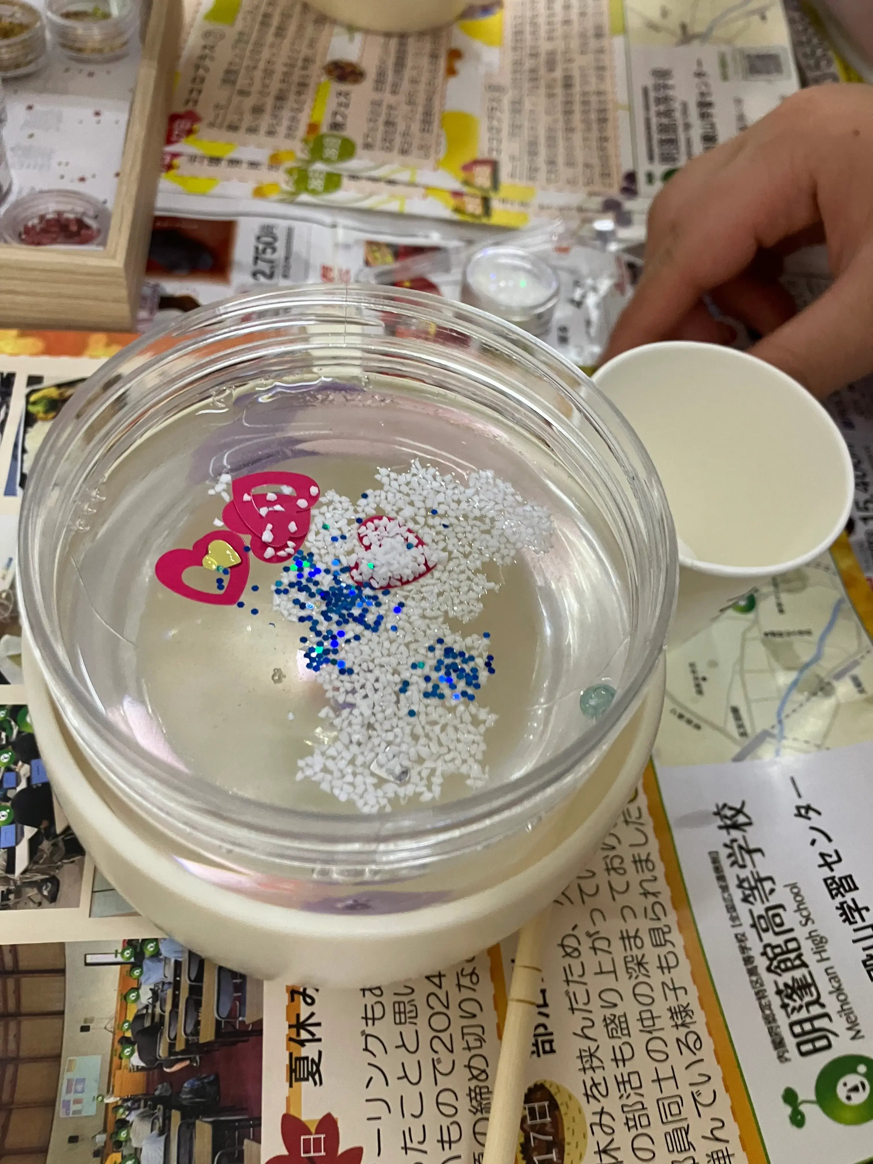 スノードームの中にラメやスノーパウダーを入れている様子