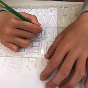 道具を使って文字を書いている