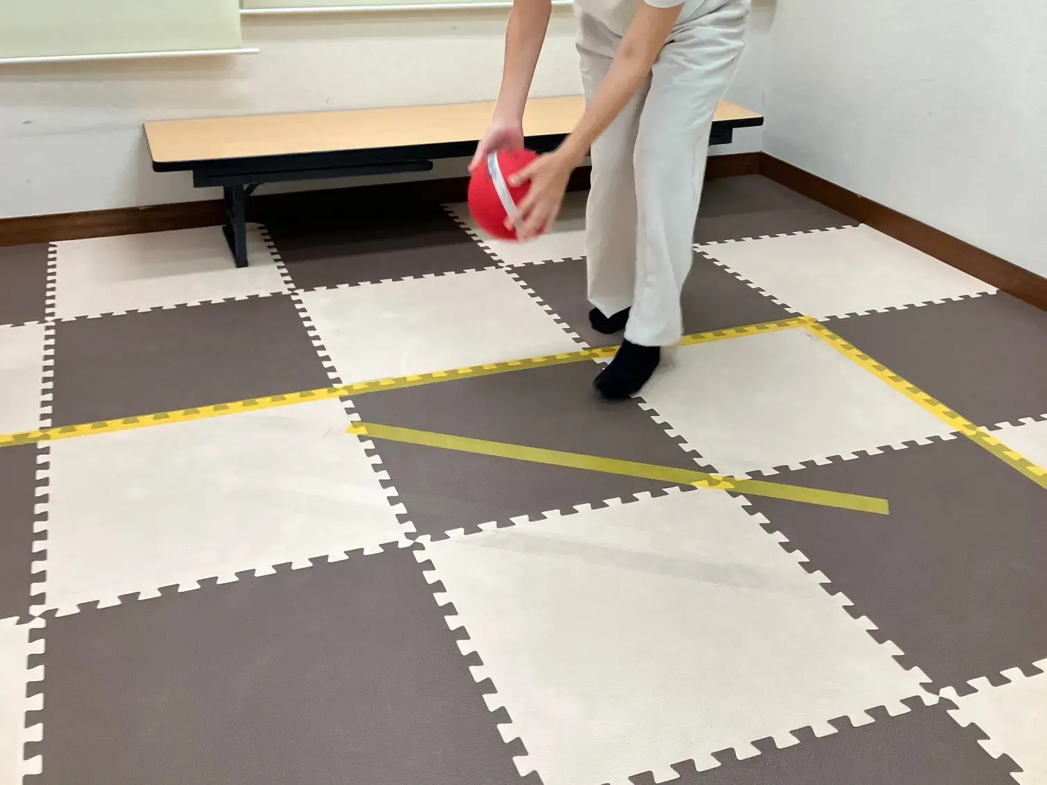 転がしドッヂボールでボールを投げる子ども